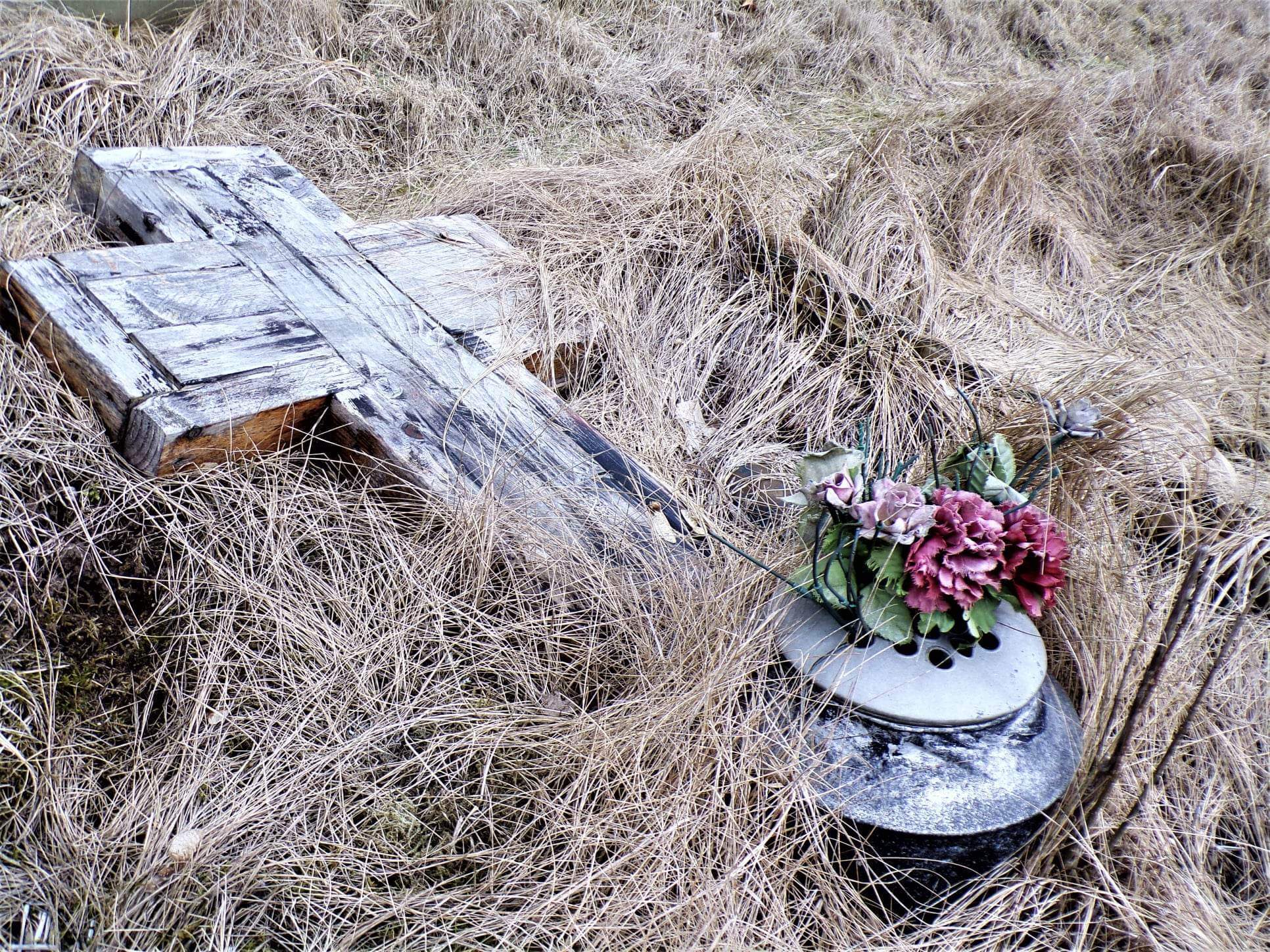 An old wooden cross hidden among the grass at St Bartholomews Church in Rainhill